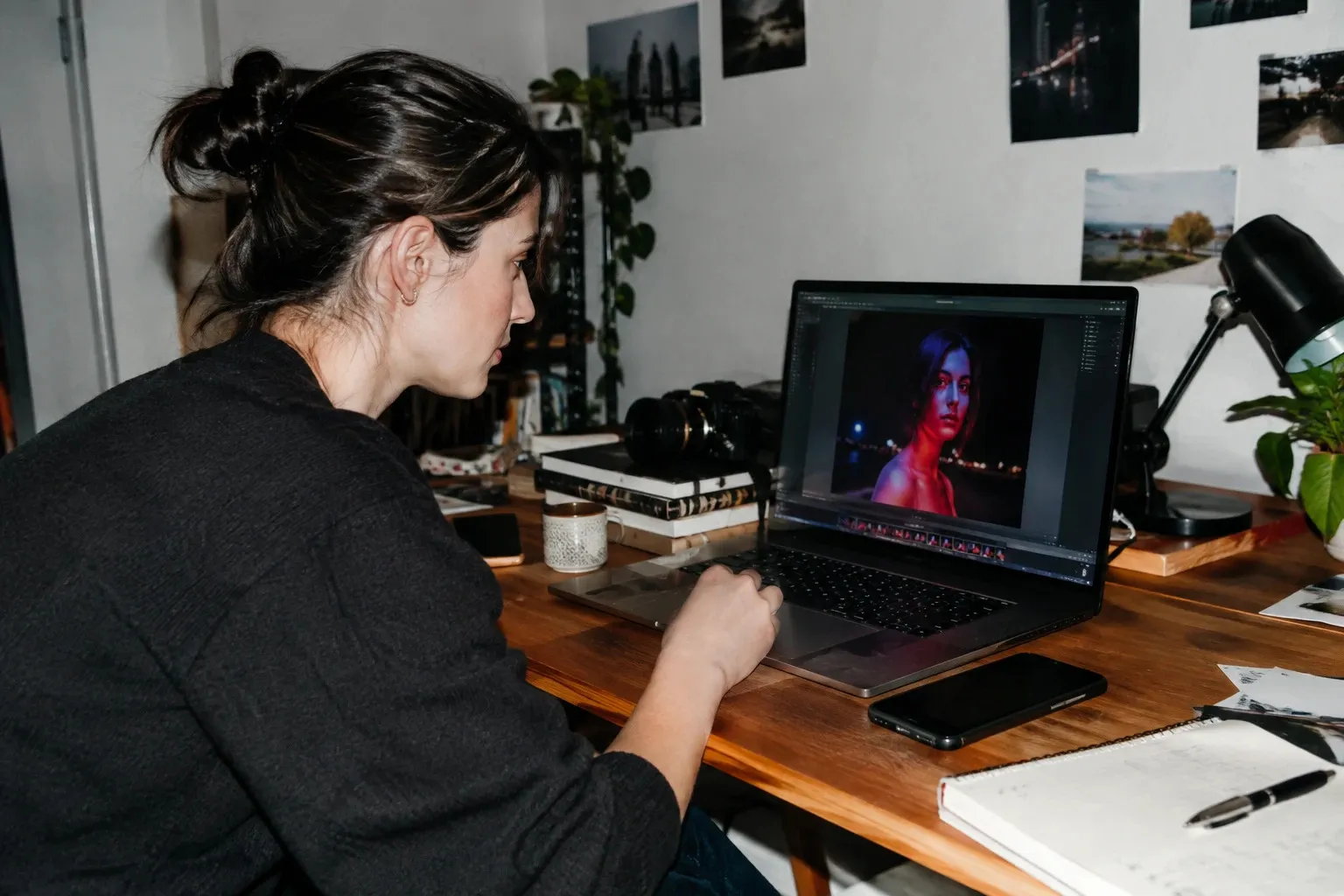 Kreative prüft ein nächtliches Porträt am Laptop Kreative prüft ein nächtliches Porträt am Laptop