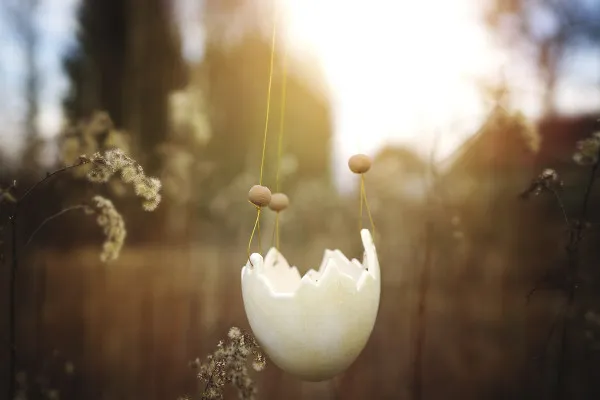 Bild eines Ostereis für zauberhafte Ostergrüße: aufgehängt an goldenen Fäden