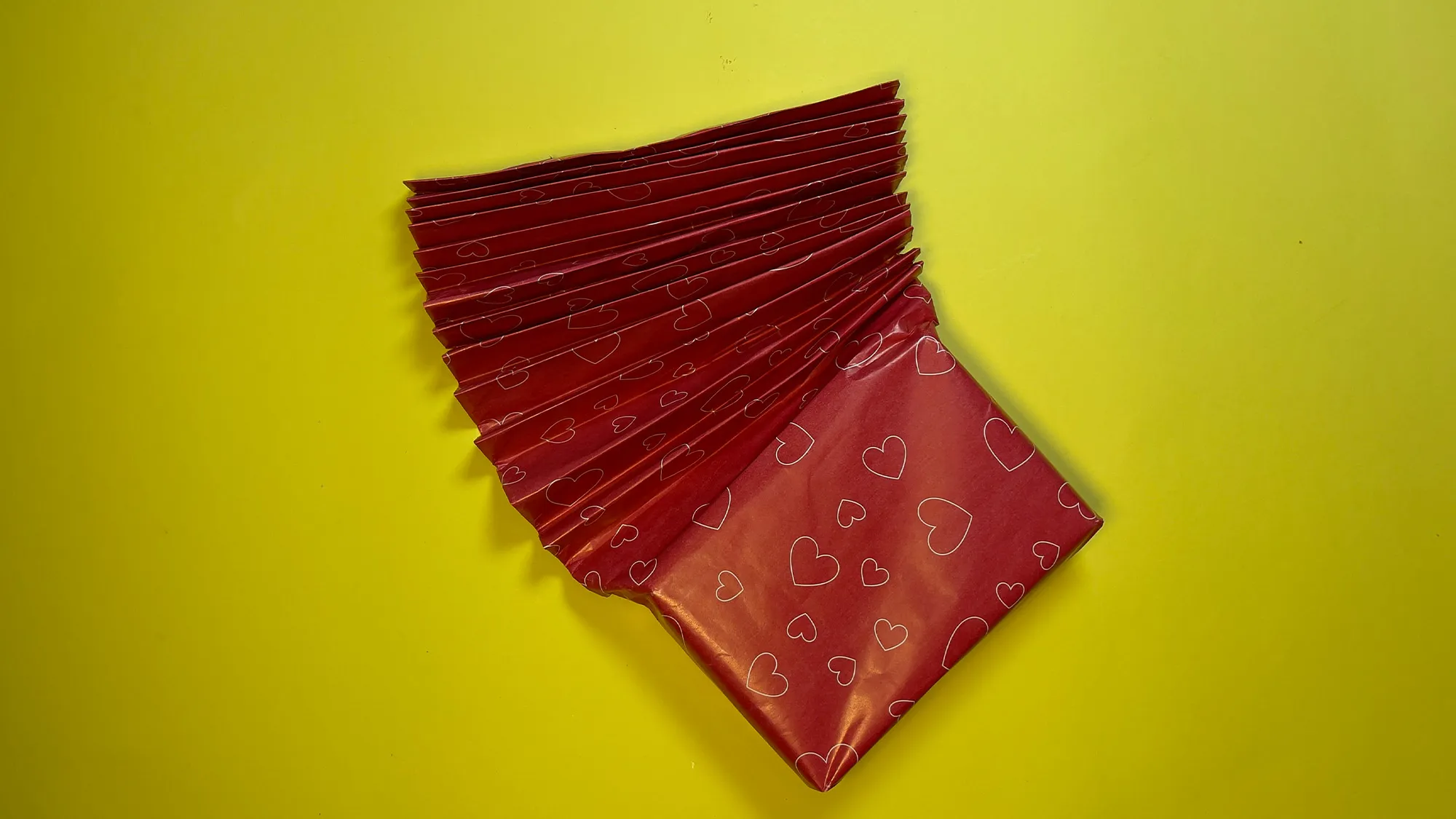 kreative-geschenkverpackung-basteln-schritt-3.jpg Kreative Geschenkverpackung basteln Schritt 3: Überstehenden Papierstreifen zu Ziehharmonika falten