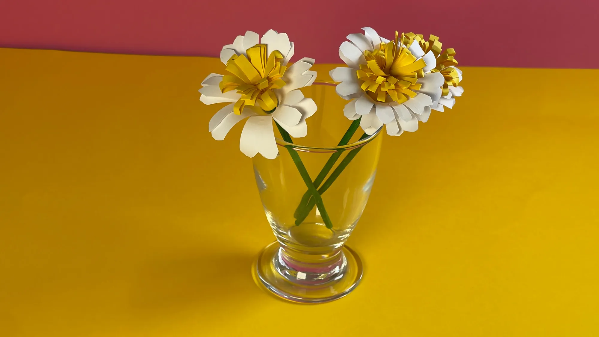 Papier-Gänseblümchen basteln Schritt 4: fertiges weißes Gänseblümchen mit gelber Mitte auf grünem Stiel