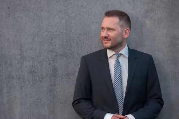 Mann foran grå vegg under fotografering av et portrettbilde for forretningsformål.