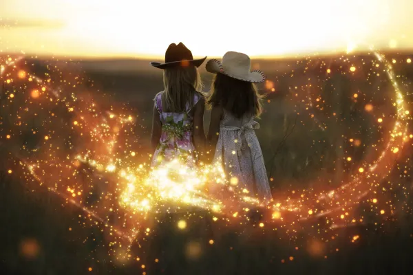 Two girls in a field, photo superimposed with glitter effect