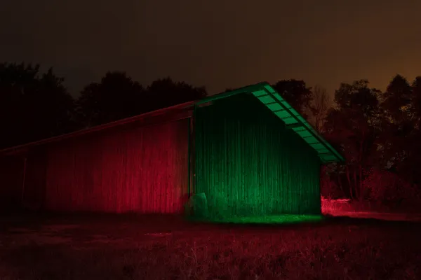 Kreative Nachtaufnahmen anfertigen – im Training wird eine im Dunkeln liegende Scheune mit Wanderlicht und Farb-LEDs beleuchtet.