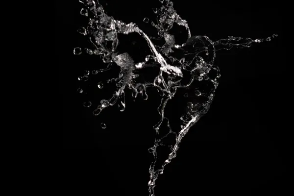 Photo of water splashes against a black background for inclusion in photomontages.