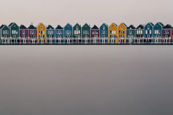 Häuser vor einem See, die Langzeitbelichtung glättet das Wasser