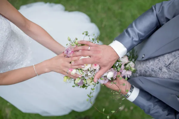 Hochzeitsfotografie: Blick auf einen Blumenstrauß, der vom Brautpaar gehalten wird