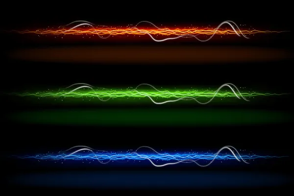 Traces de lumière de différentes couleurs, orange, vert et bleu.