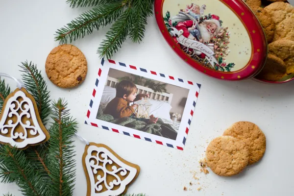 Weihnachtlicher Hintergrund mit einer Postkarte, auf der ein Foto platziert wurde