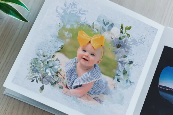 Foto eines Babys in einem Aquarell-Rahmen mit Blumen, ausgedruckt in einem Fotobuch